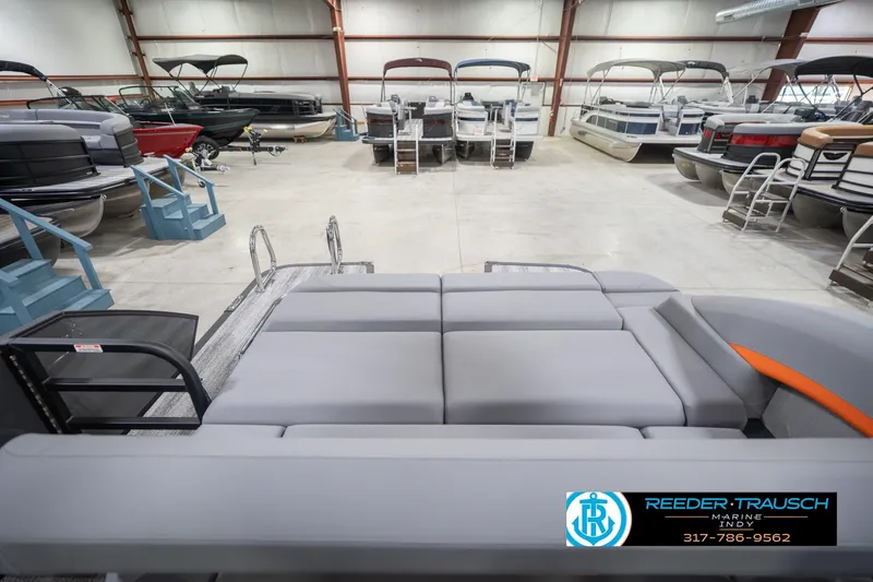 Slide: The Image of 2026 Bennington 24 MSB pontoon boat in showroom with multiple boats displayed. - 18