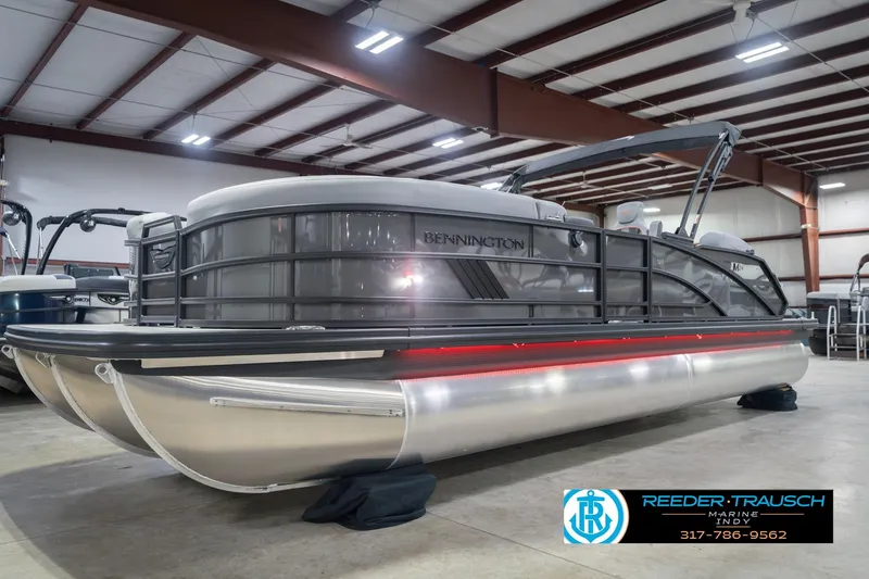 Slide: The Image of 2026 Bennington 24 MSB pontoon boat in showroom, side view with sleek design. - 3