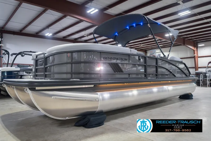 Slide: The Image of 2026 Bennington 24 MSB pontoon boat in showroom with canopy and sleek design. - 4