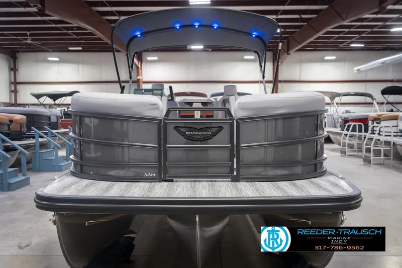 Slide: The Image of 2026 Bennington 24 MSB pontoon boat in showroom with blue LED lights. - 5