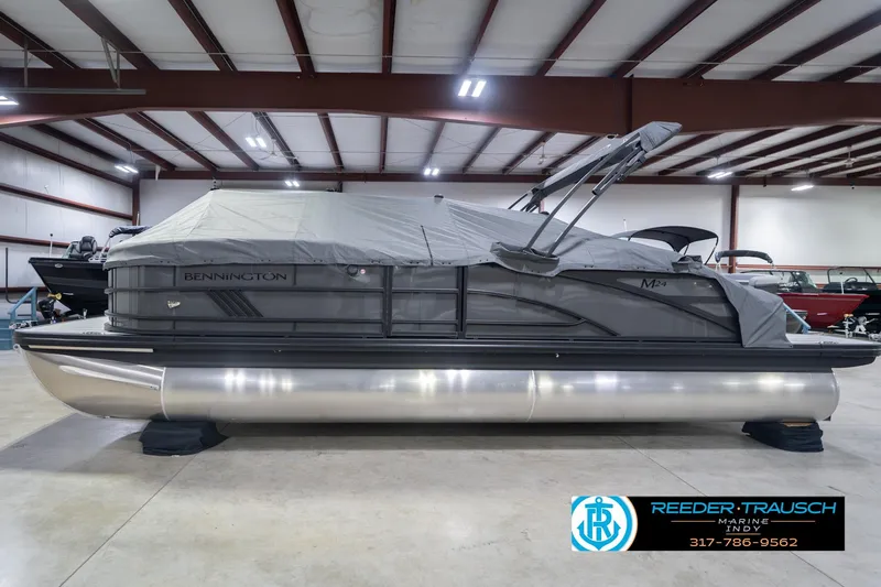 Slide: The Image of 2026 Bennington 24 MSB pontoon boat in indoor showroom with cover. - 63