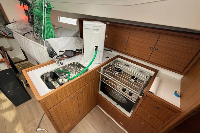 Slide: The Image of Interior of 2022 J Boats J/112E yacht featuring a compact kitchen with stove and sink. - 31