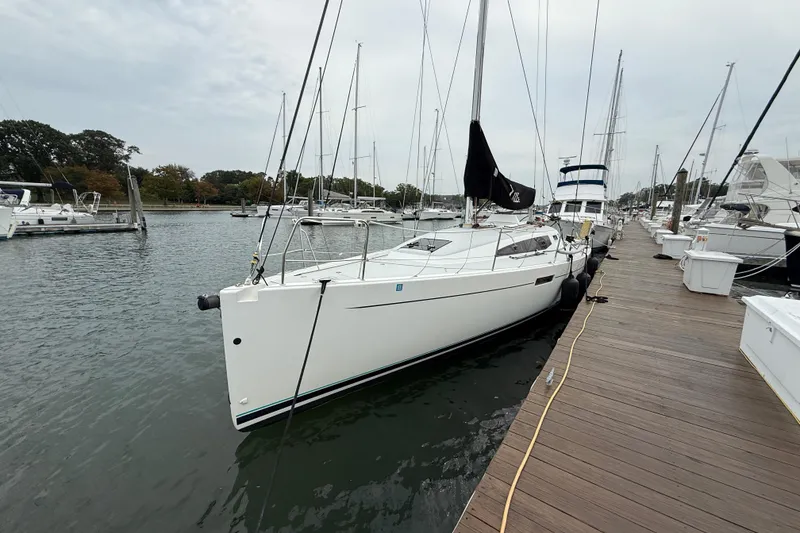 Slide: The Image of 2022 J Boats J/112E sailboat docked at a marina, surrounded by other vessels. - 4