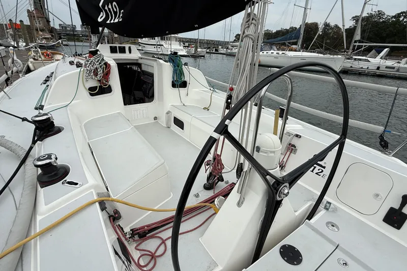 Slide: The Image of 2022 J Boats J/112E sailboat cockpit with steering wheel and rigging, docked in marina. - 8
