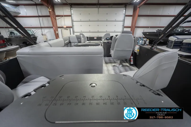 Slide: The Image of 2026 Bennington 21 SF boat interior with gray seating, showcased in a showroom. - 19