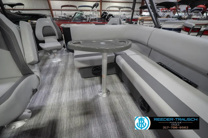 Slide: The Image of 2026 Bennington 21 SF boat interior with gray seating and table, showcased at Reeder-Trausch Marine. - 28