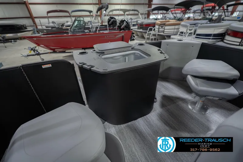 Slide: The Image of 2026 Bennington 21 SF boat interior with seating and storage, displayed in a showroom. - 33