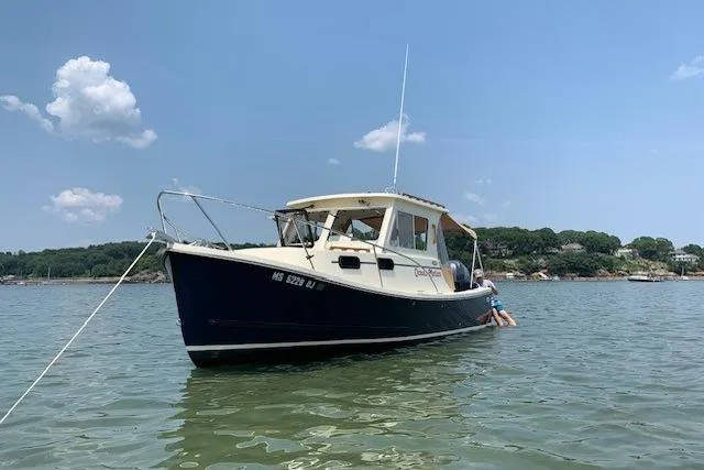 Slide: The Image of 2015 Eastern 248 Islander boat anchored on calm water under a clear blue sky. - 2