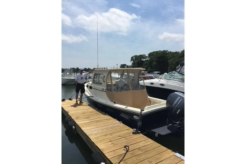 Slide: The Image of 2015 Eastern 248 Islander boat docked at marina with person standing nearby. - 4