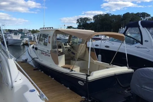 Slide: The Image of 2015 Eastern 248 Islander boat docked at marina under blue sky. - 5