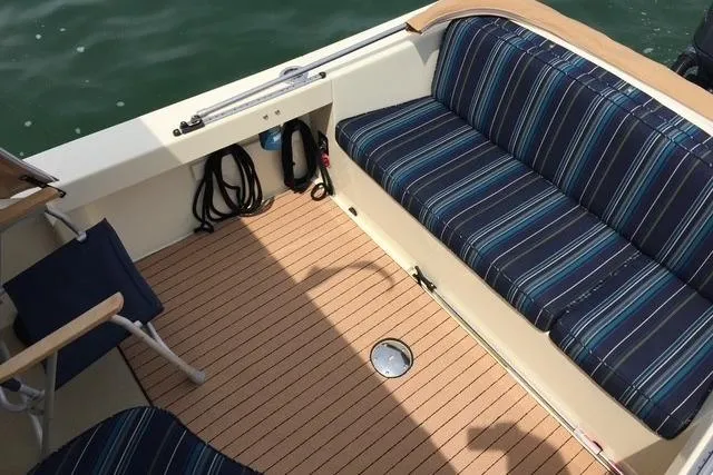 Slide: The Image of 2015 Eastern 248 Islander boat interior with striped seating and wooden deck. - 8