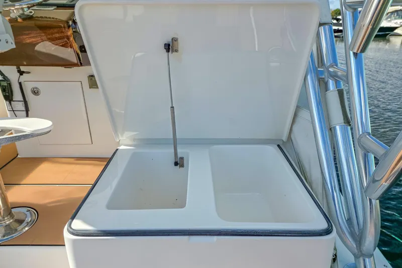 Slide: The Image of Open storage compartment on 2005 Egg Harbor 35' Express boat, docked by the water. - 14