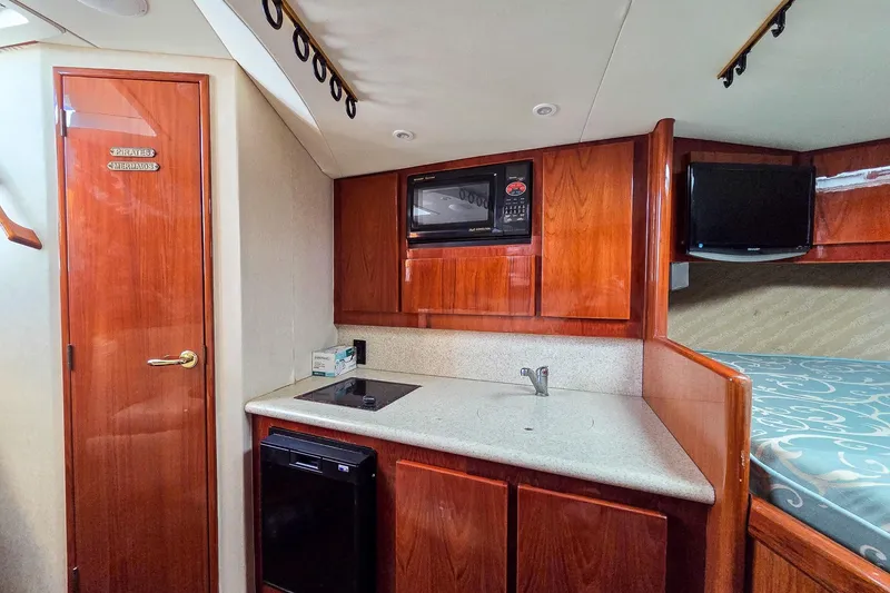 Slide: The Image of Interior of 2005 Egg Harbor 35' Express yacht with kitchenette and wooden cabinetry. - 22