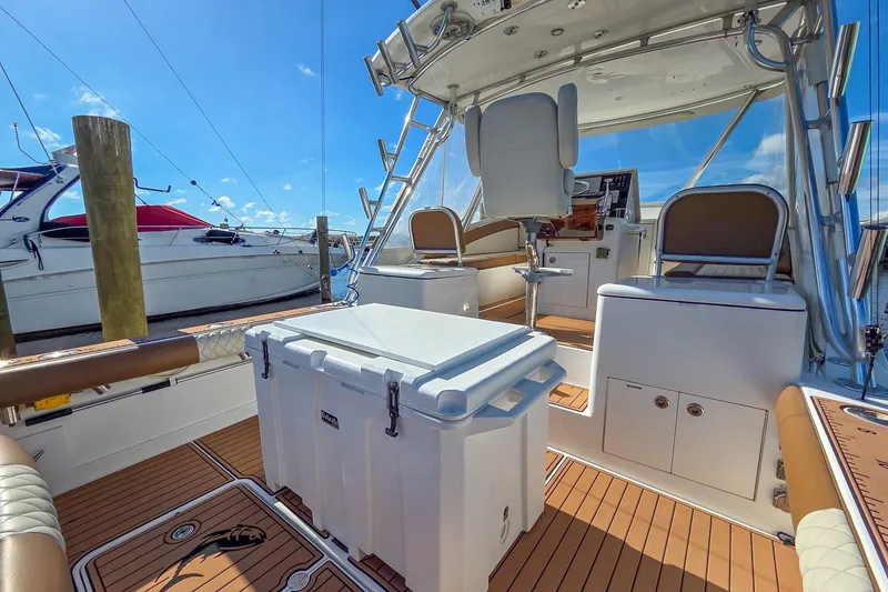 Slide: The Image of 2005 Egg Harbor 35' Express boat interior with seating and cooler on a sunny day. - 31