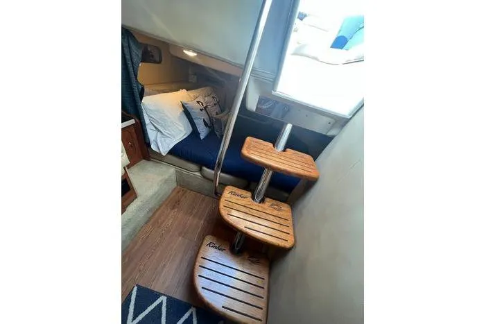 Slide: The Image of 2002 Rinker 342 Fiesta Vee cabin interior with wooden steps and cozy sleeping area. - 10