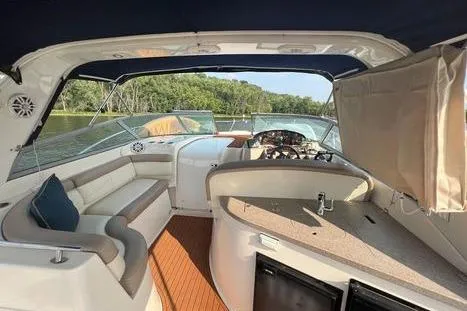 Slide: The Image of 2002 Rinker 342 Fiesta Vee boat interior with seating, helm, and kitchenette on a sunny day. - 14