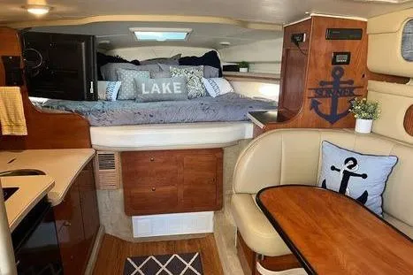 Slide: The Image of 2002 Rinker 342 Fiesta Vee cabin interior with nautical decor and cozy sleeping area. - 4