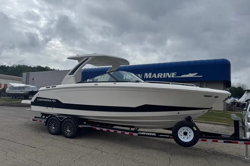 Slide: The Image of 2026 Chaparral 30 SSX boat on trailer, parked outside marine dealership. - 1
