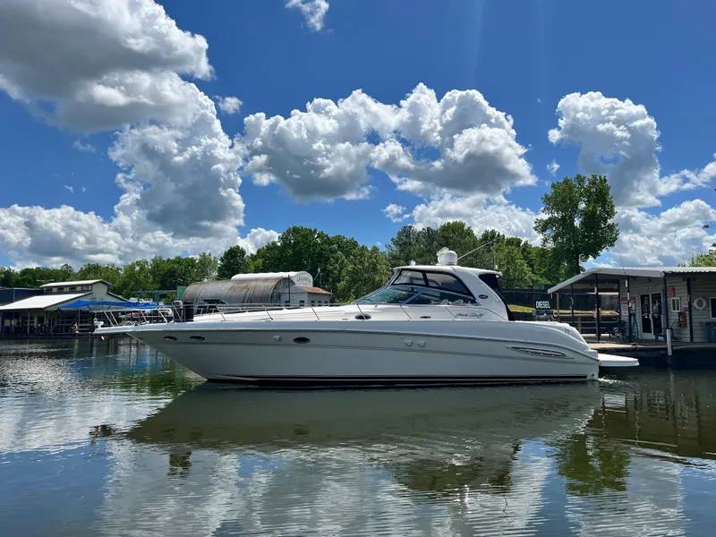 The Image of 2003 Sea Ray 460 Sundancer yacht docked on a sunny day with fluffy clouds. - 0