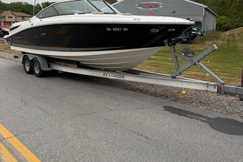 The Image of 2005 Sea Ray 270 SLX boat on EZ Loader trailer, parked on roadside. - 0