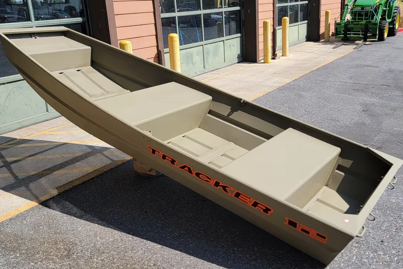 Slide: The Image of 2026 Tracker Grizzly 12 Jon boat displayed outdoors near a building. - 2