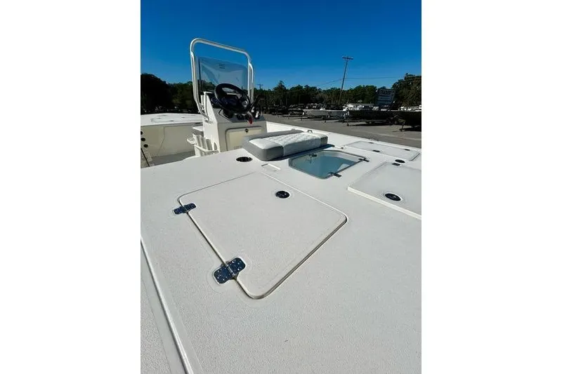 Slide: The Image of 2026 Mako 18 Pro Skiff boat deck with storage compartments and steering console. - 10