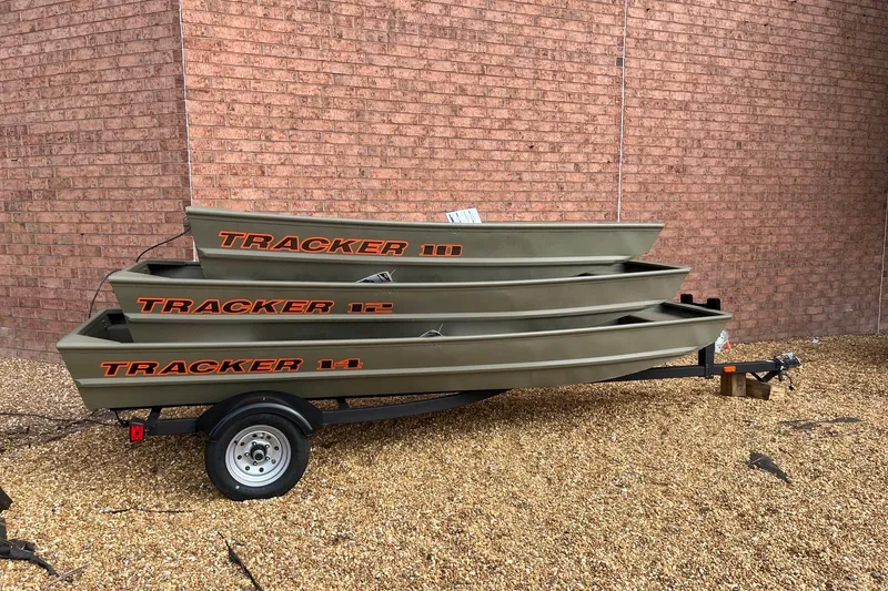 The Image of 2026 Tracker Grizzly 10 Jon boats stacked on trailer against brick wall. - 0
