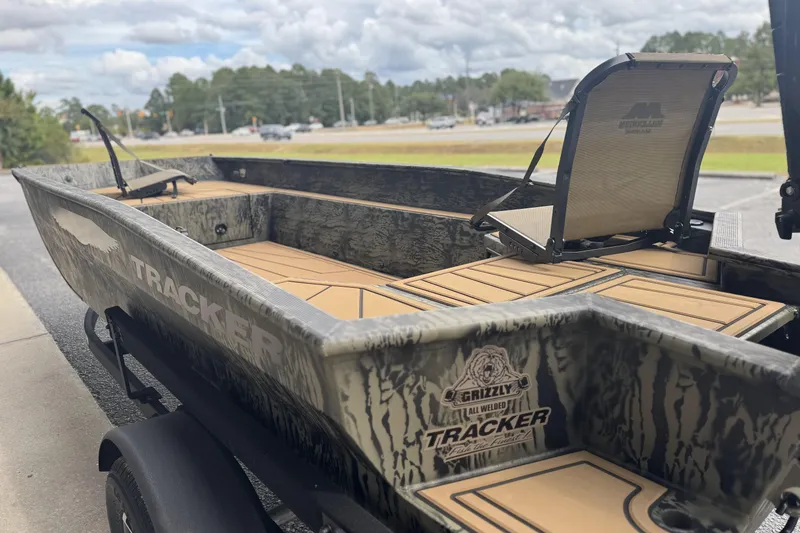 Slide: The Image of 2026 Tracker Grizzly 1650 T Prairie Wings Edition boat on trailer, parked outside. - 15