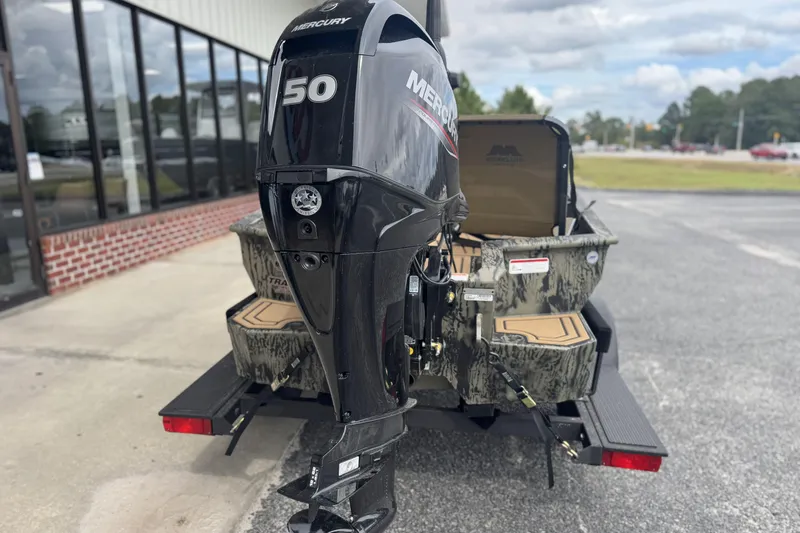 Slide: The Image of 2026 Tracker Grizzly 1650 T Prairie Wings Edition with Mercury 50 engine, parked outdoors. - 9