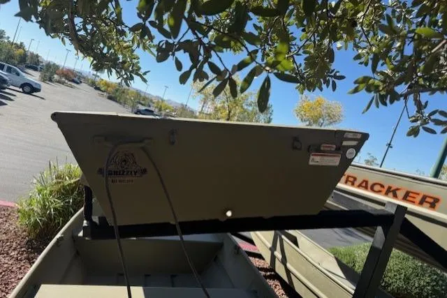 Slide: The Image of 2026 Tracker Grizzly 10 Jon boat displayed outdoors under tree branches. - 3