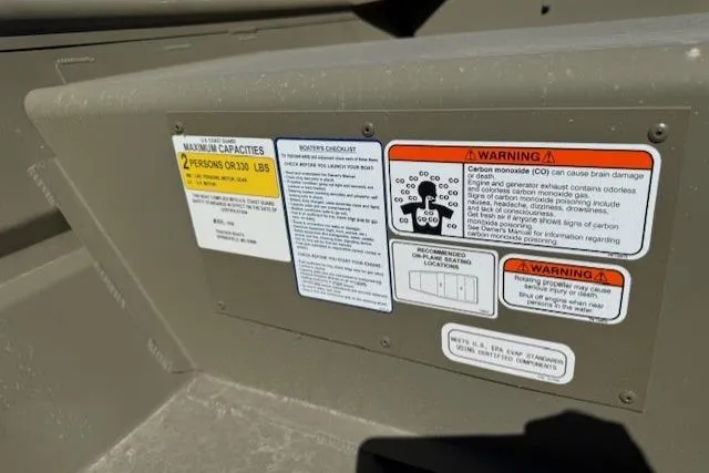 Slide: The Image of 2026 Tracker Grizzly 10 Jon boat warning and capacity labels on interior panel. - 4