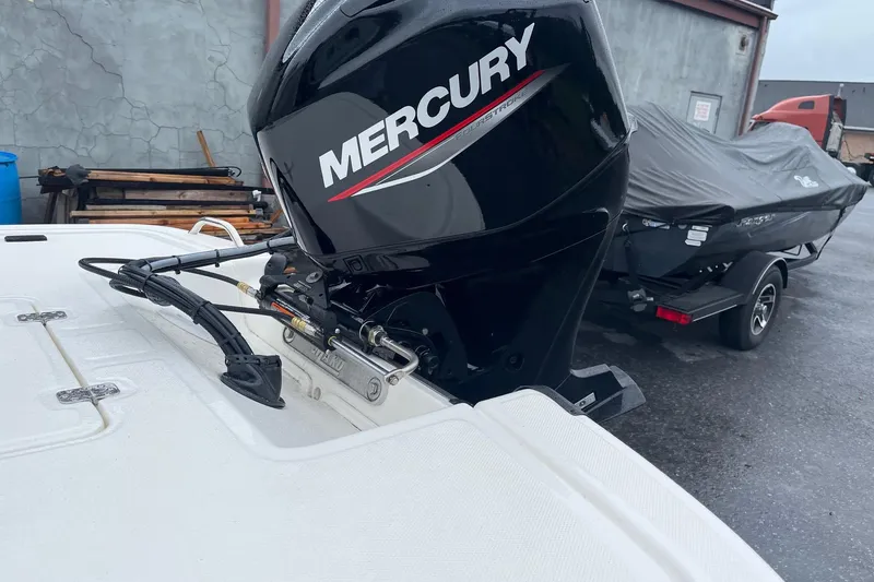 Slide: The Image of 2026 Mako Pro Skiff 17 CC with Mercury outboard motor in a parking area. - 5