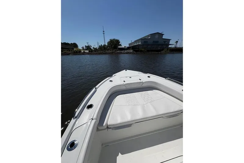 Slide: The Image of Bow view of 2026 Parker 180 Coastal boat on calm water near a building. - 10