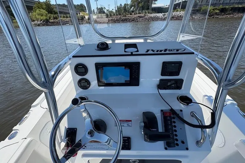 Slide: The Image of 2026 Parker 180 Coastal boat dashboard with steering wheel and navigation controls. - 15