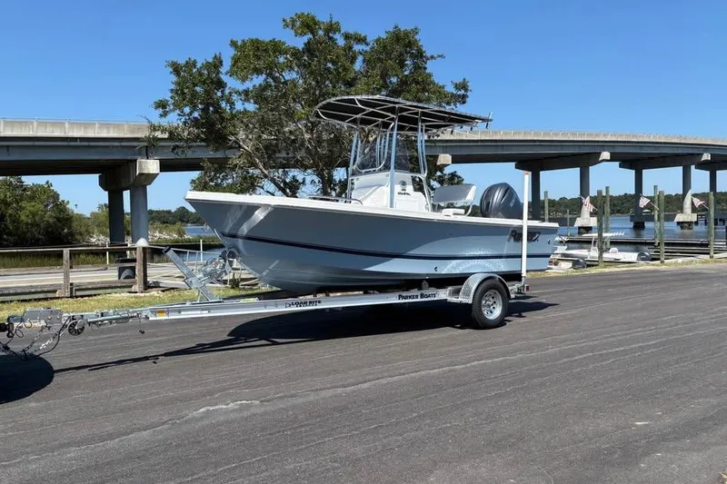 Slide: The Image of 2026 Parker 180 Coastal boat on trailer near bridge and waterway. - 6