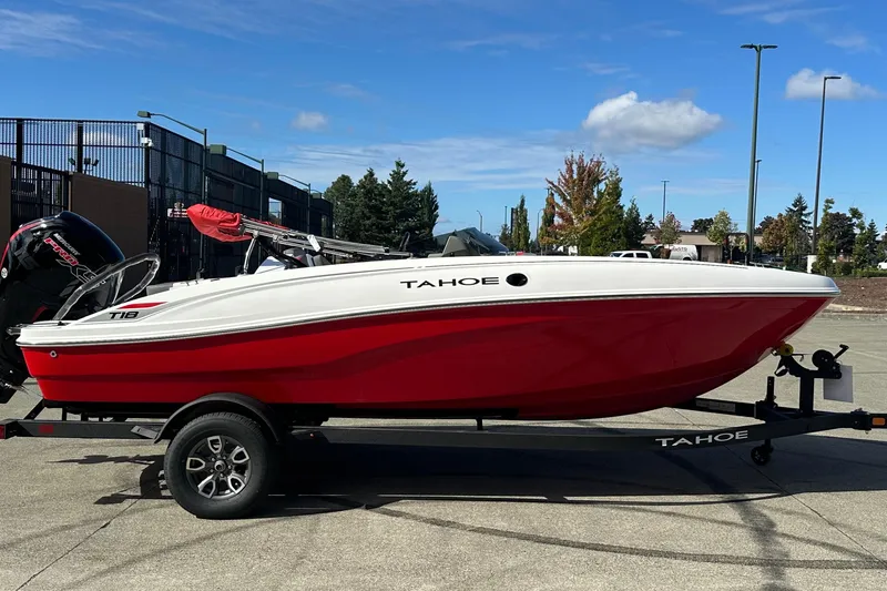 The Image of 2026 Tahoe T18 boat in red and white on a trailer, parked outdoors. - 0