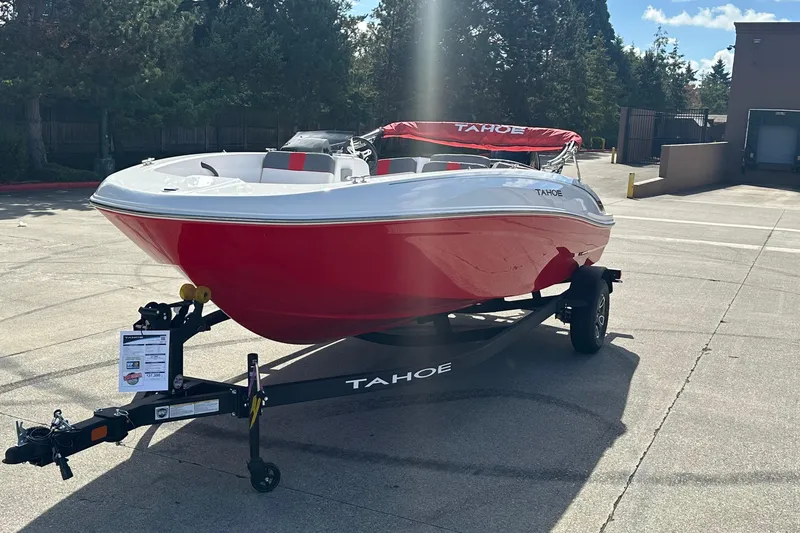 Slide: The Image of 2026 Tahoe T18 boat in red and white on a trailer, parked outdoors. - 2