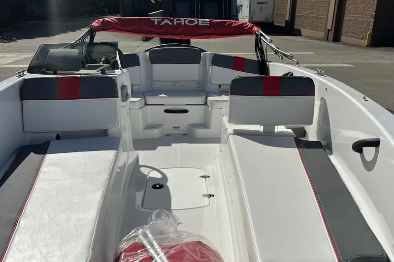 Slide: The Image of 2026 Tahoe T18 boat interior with red and gray seating, docked outdoors. - 5