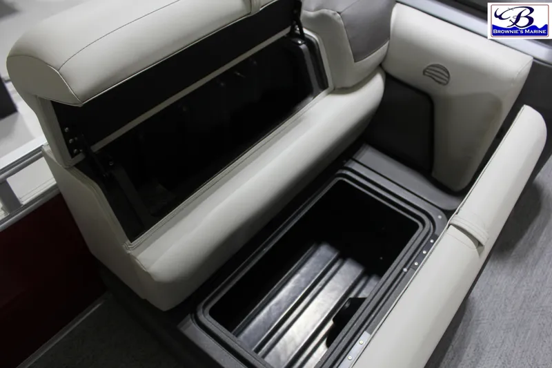 Slide: The Image of 2026 Sun Tracker Fishin' Barge 22 DLX storage compartment with open seat cushion. - 11