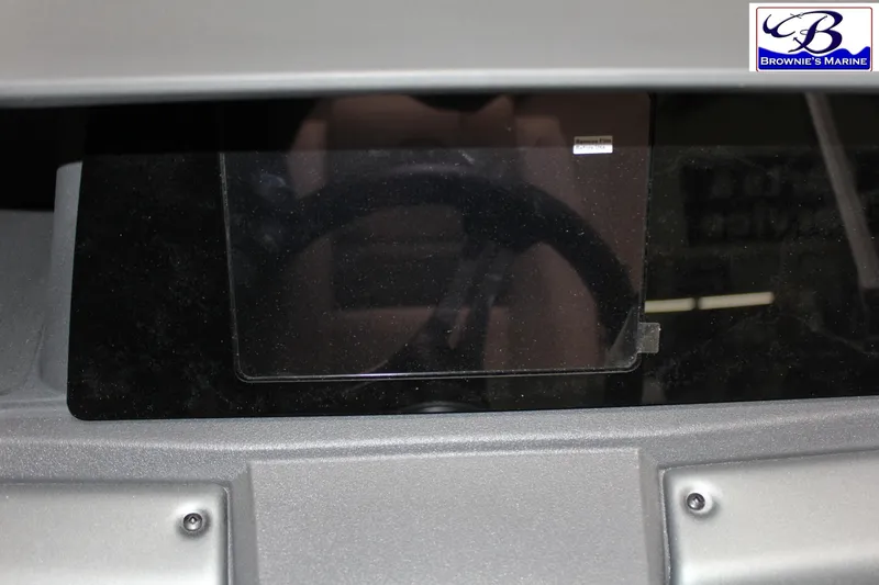 Slide: The Image of 2026 Sun Tracker Fishin' Barge 22 DLX dashboard with steering wheel, Brownie's Marine logo. - 19