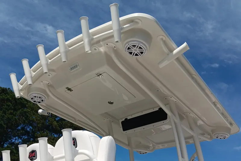 Slide: The Image of 2026 Ranger 2360 Bay boat T-top with rod holders and speakers against blue sky. - 12