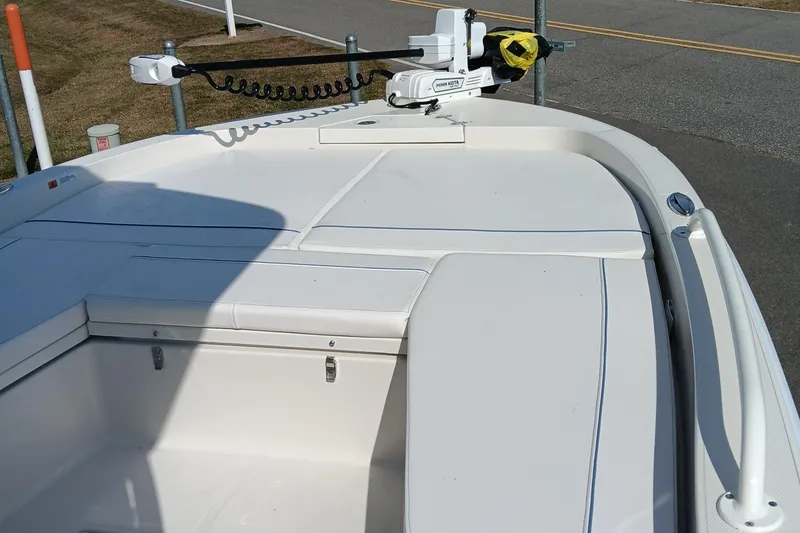 Slide: The Image of 2026 Ranger 2360 Bay boat deck with Minn Kota trolling motor, parked on roadside. - 16