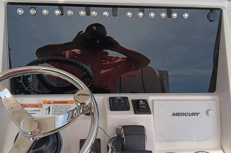 Slide: The Image of 2026 Ranger 2360 Bay boat dashboard with steering wheel and Mercury controls. - 26