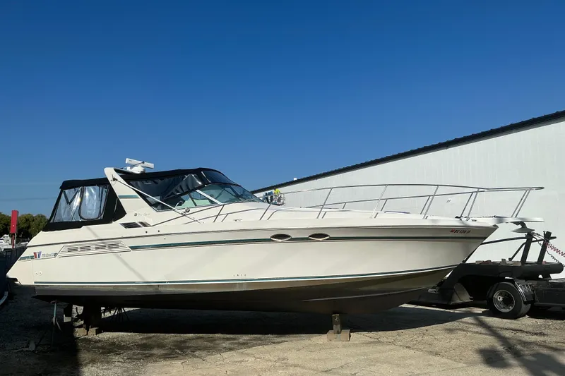 The Image of 1992 Wellcraft 3400 Gran Sport boat on trailer under clear blue sky. - 0