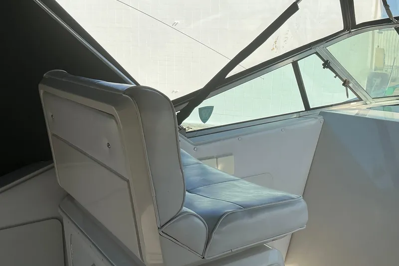 Slide: The Image of 1992 Wellcraft 3400 Gran Sport boat interior with cushioned seating and windshield. - 13