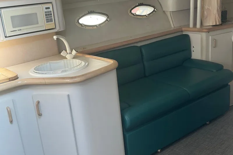 Slide: The Image of Interior of 1992 Wellcraft 3400 Gran Sport with teal sofa and kitchenette. - 22