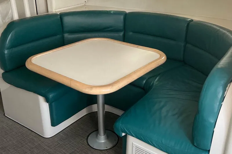 Slide: The Image of 1992 Wellcraft 3400 Gran Sport interior with teal leather seating and a wooden table. - 27