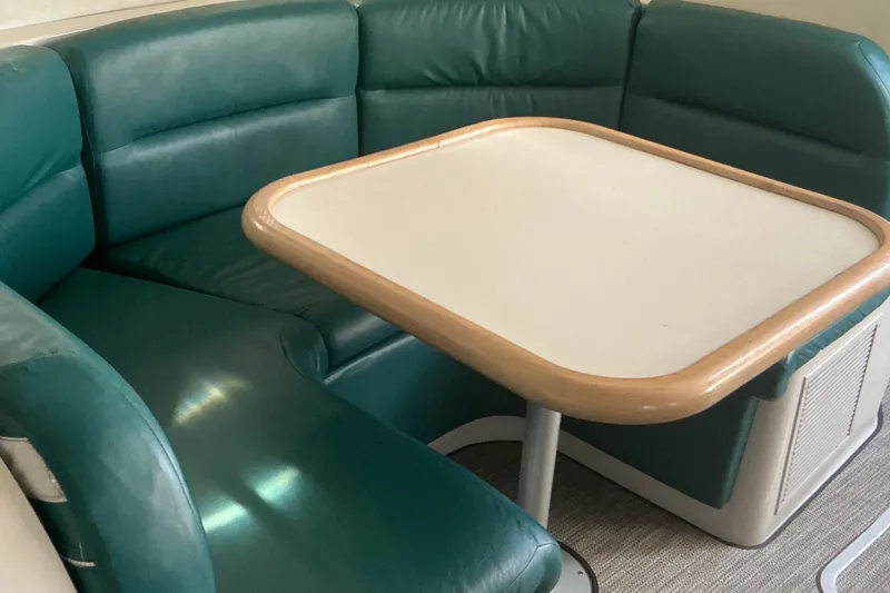 Slide: The Image of 1992 Wellcraft 3400 Gran Sport interior with green leather seating and a wooden table. - 28