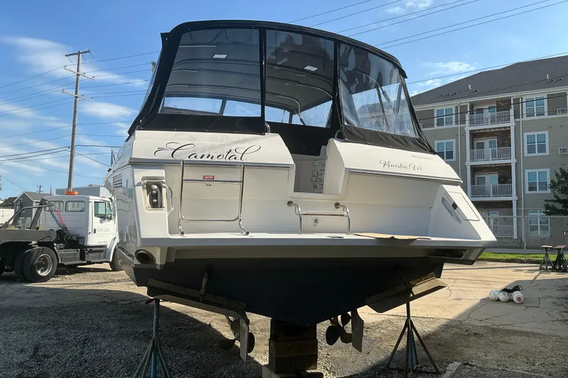 Slide: The Image of 1992 Wellcraft 3400 Gran Sport boat on stands, with buildings and truck in background. - 6