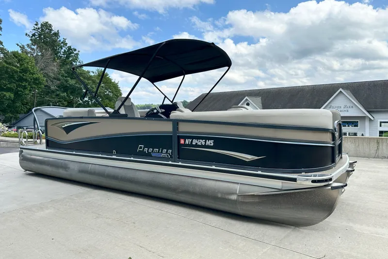 The Image of 2021 Premier 250 Solaris RE pontoon boat with canopy, parked outdoors under a cloudy sky. - 0